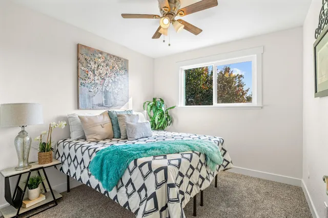 a bedroom with a bed and a painting on the wall