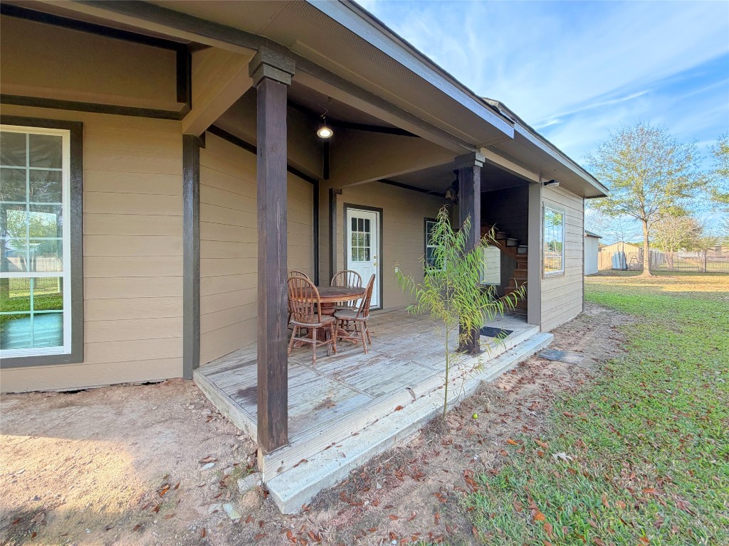 369 Road 3556 Cleveland, TX 77327 - Photo 6 of 16 a view of a porch with chairs and table