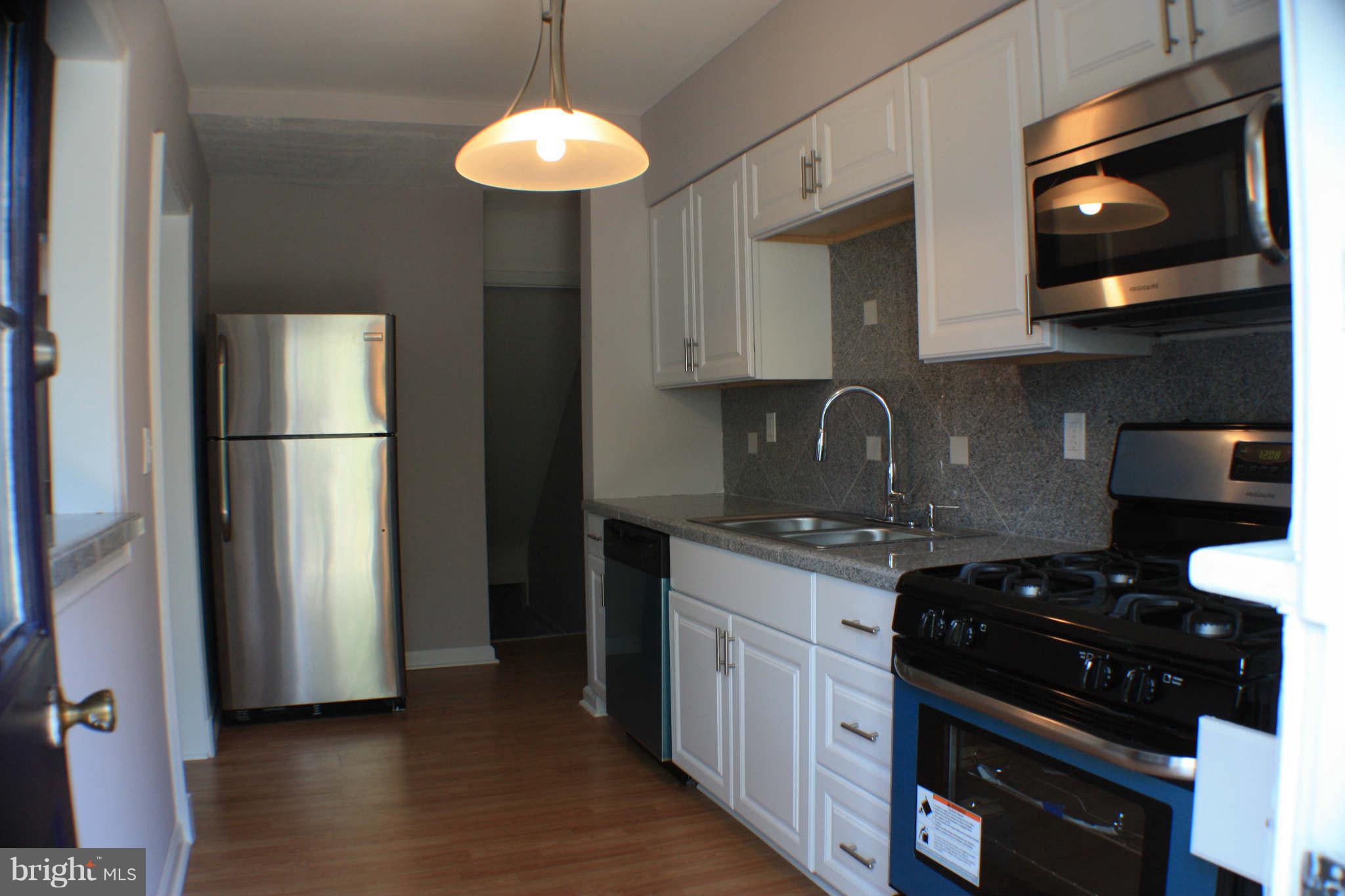 1540 Gleneagle Road Baltimore, MD 21239 - Photo 1 of 14 a kitchen with stainless steel appliances granite countertop a refrigerator a sink a stove and microwave