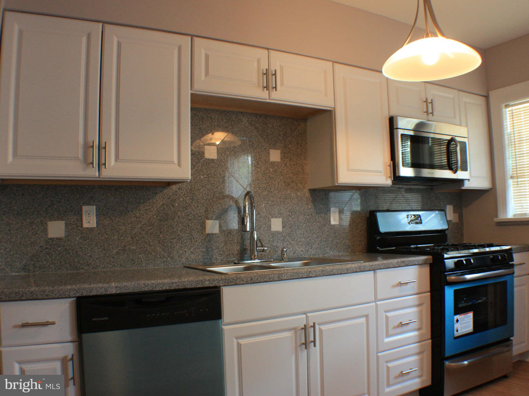 1540 Gleneagle Road Baltimore, MD 21239 - Photo 2 of 14 a kitchen with stainless steel appliances granite countertop a sink a stove and a microwave