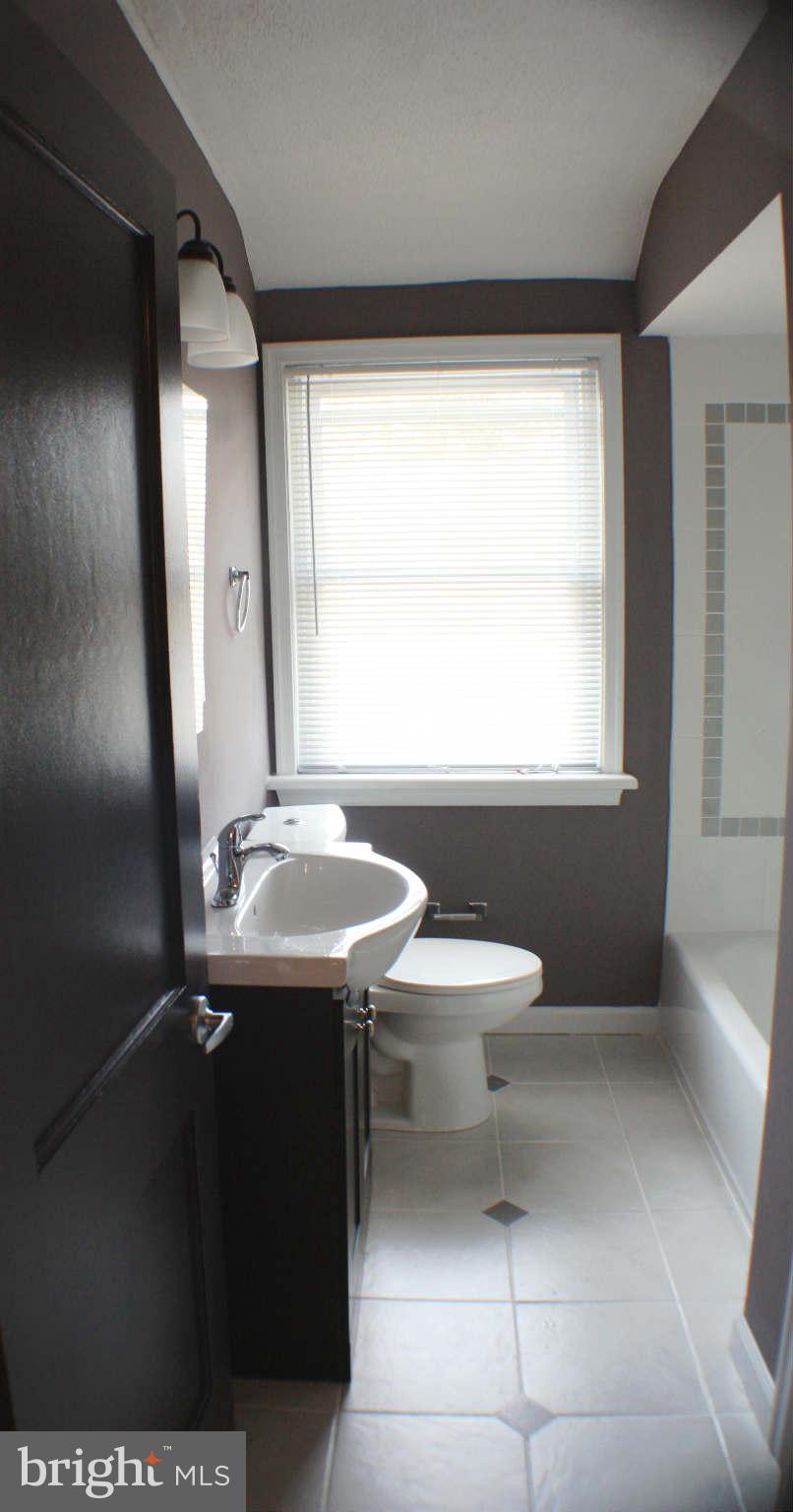 1540 Gleneagle Road Baltimore, MD 21239 - Photo 4 of 14 a bathroom with a sink a toilet and window
