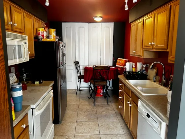 a kitchen filled a sink a counter and chairs