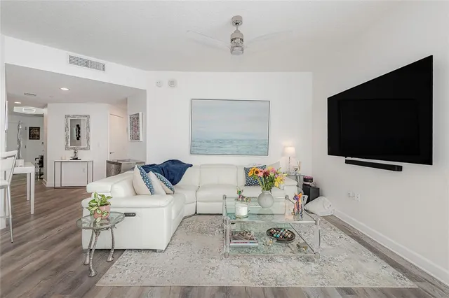 a living room with furniture a flat screen tv and a large window