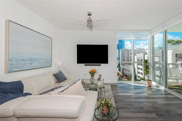 a living room with furniture a flat screen tv and a chandelier