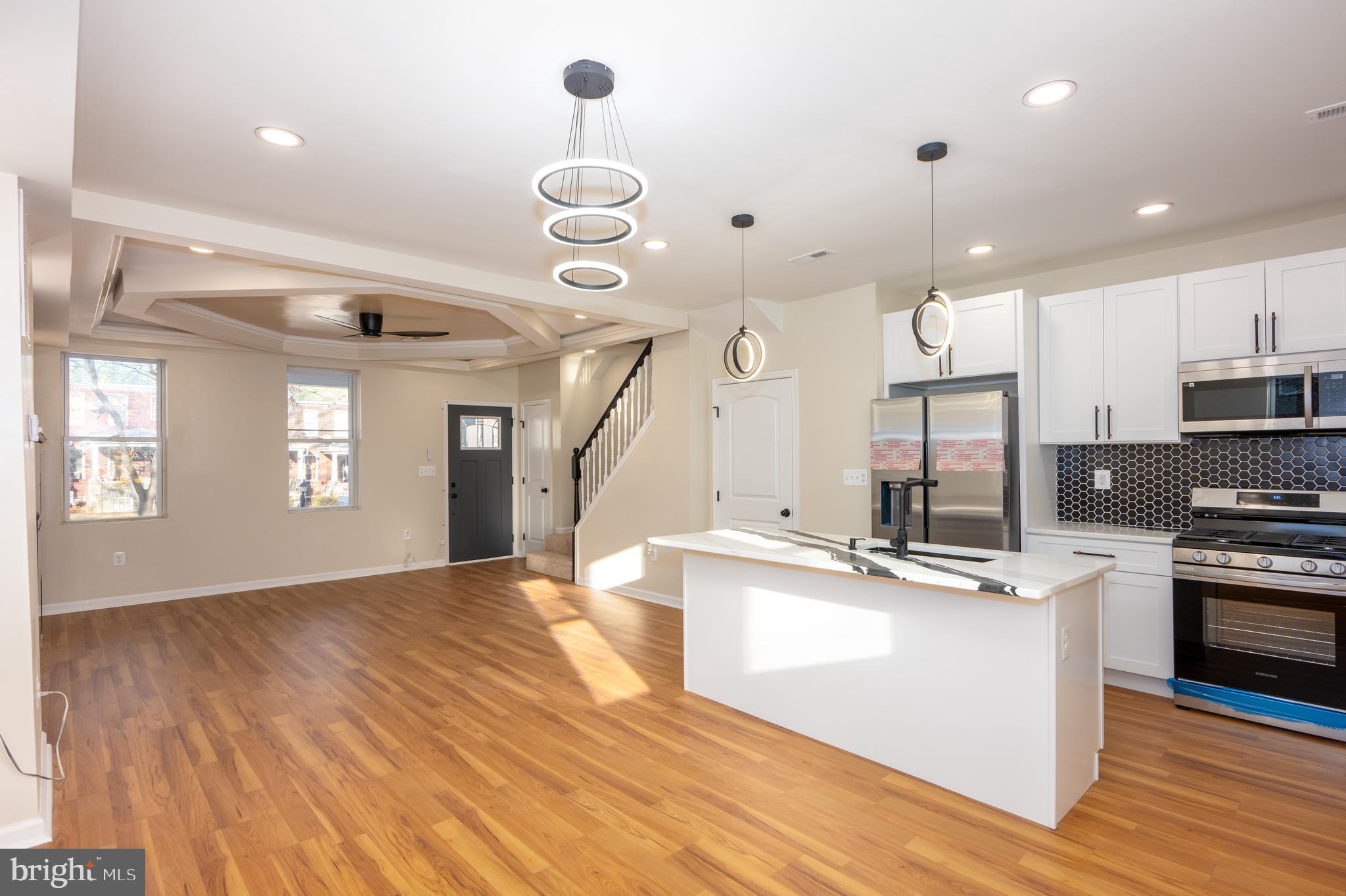 3121 Sequoia Avenue Baltimore, MD 21215 - Photo 8 of 30 a large kitchen with stainless steel appliances kitchen island granite countertop a sink and a wooden floor