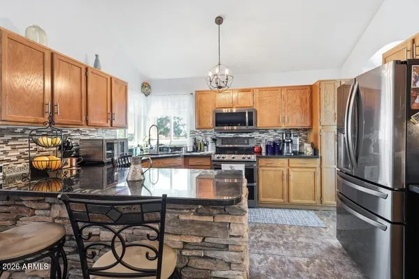 a kitchen with stainless steel appliances granite countertop a stove a sink and a refrigerator