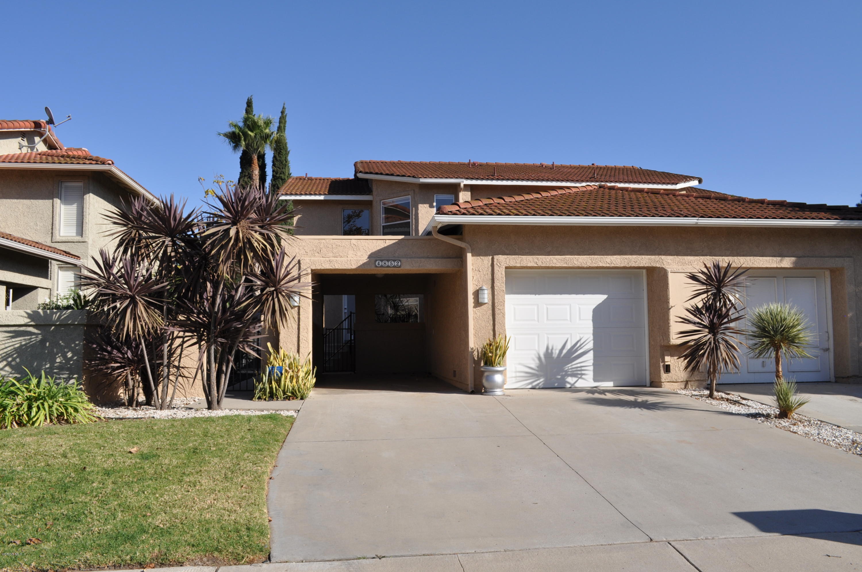 a view of a house with a small yard and plants