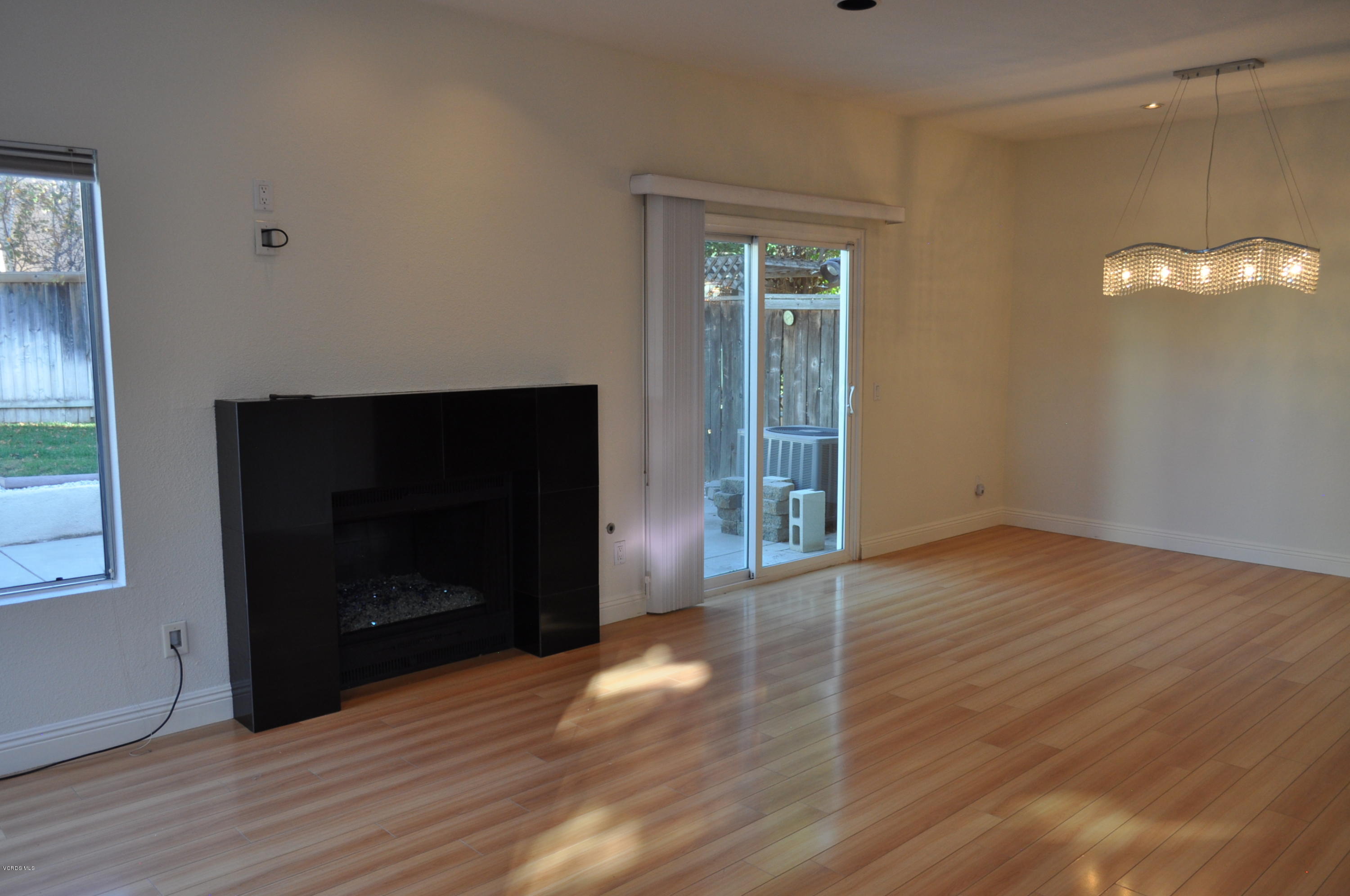 4852 Penrose Avenue Moorpark, CA 93021 - Photo 7 of 20 a view of an empty room with wooden floor and a fireplace