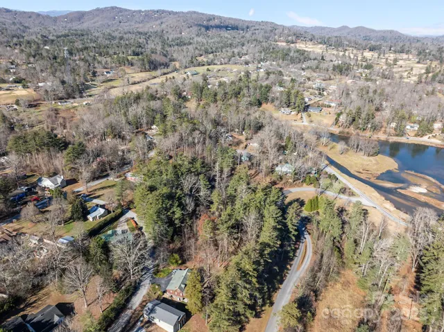 an aerial view of residential houses with outdoor space and trees