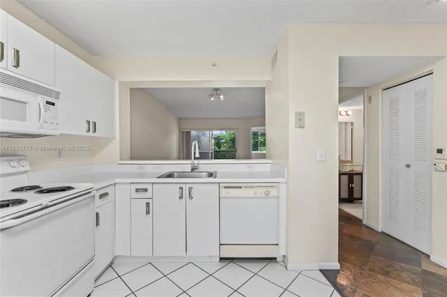a kitchen with white cabinets appliances and a sink