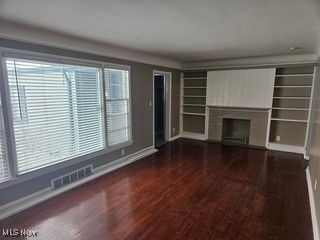 220 Greenvale Road Cleveland, OH 44121 - Photo 2 of 9 Unfurnished living room with dark wood-style floors and a fireplace