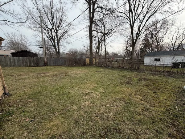 a view of a yard with trees in front of it