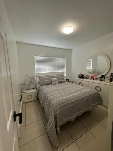 a bedroom with a bed and a lamp with the dresser