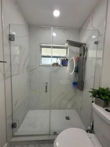 a bathroom with a shower a toilet and a shower