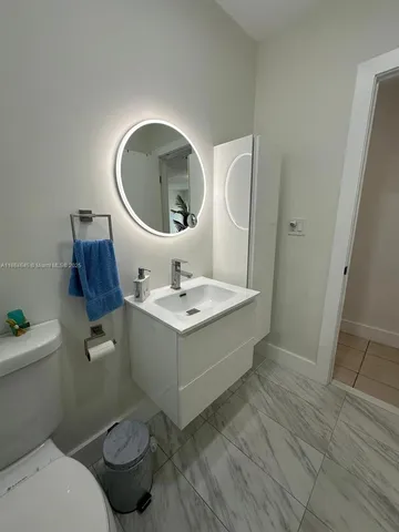 a bathroom with a sink toilet and mirror