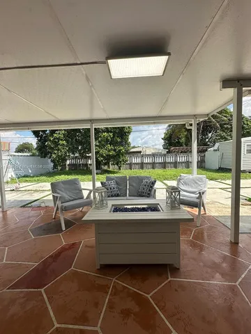 a living room with furniture a flat screen tv and a table