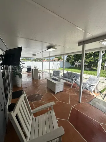 a living room with patio furniture and white walls