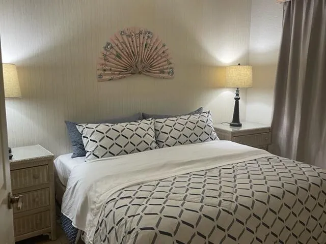a large bed sitting in a bedroom next to a lamp