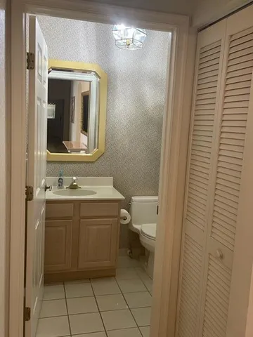 a bathroom with a toilet sink and mirror