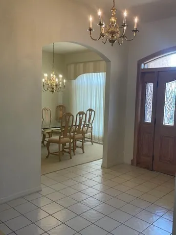 a view of a dining room with furniture and chandelier