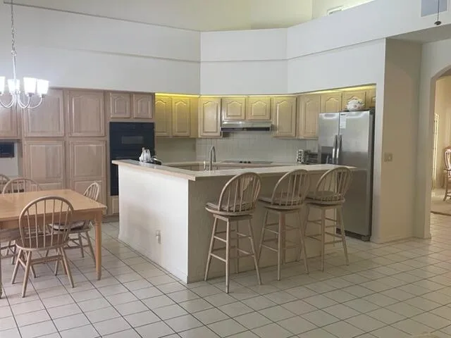 a kitchen with stainless steel appliances granite countertop a table chairs sink and cabinets
