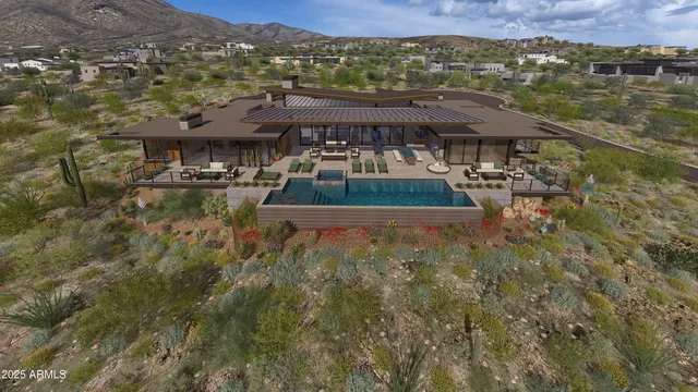 a view of a patio with dining table and chairs under an umbrella with a barbeque