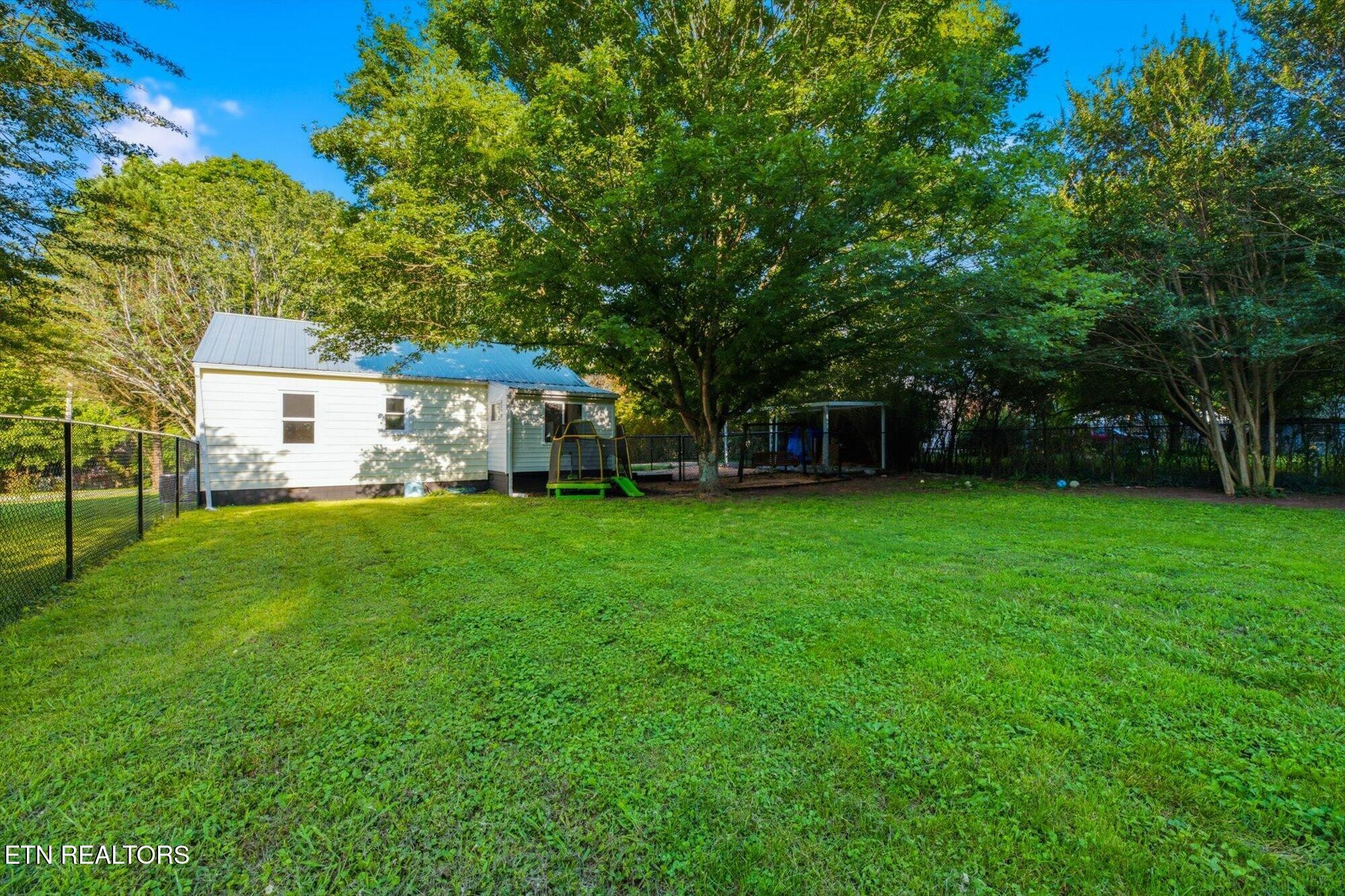 159 Mill Street Delano, TN 37325 - Photo 21 of 22 a view of a white house in front of a big yard with large trees