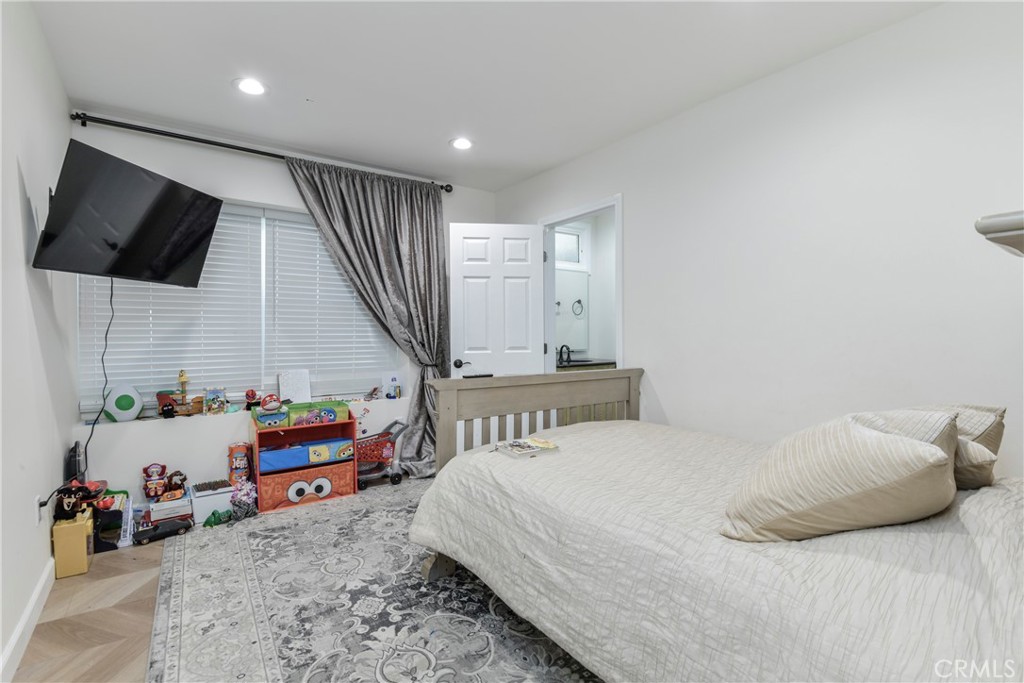 9728 Rhea Avenue Northridge, CA 91324 - Photo 20 of 36 a bedroom with a bed a flat screen tv and a couch