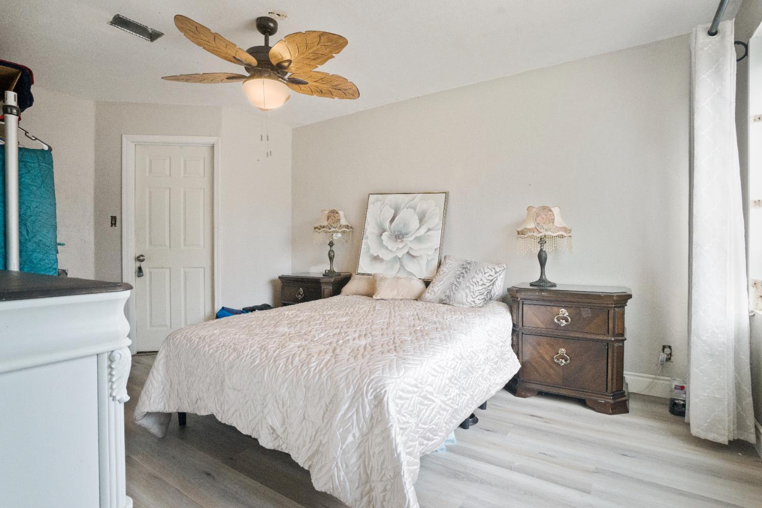 1403 East Griffith Way Fresno, CA 93704 - Photo 22 of 27 a bedroom with a bed and a chandelier