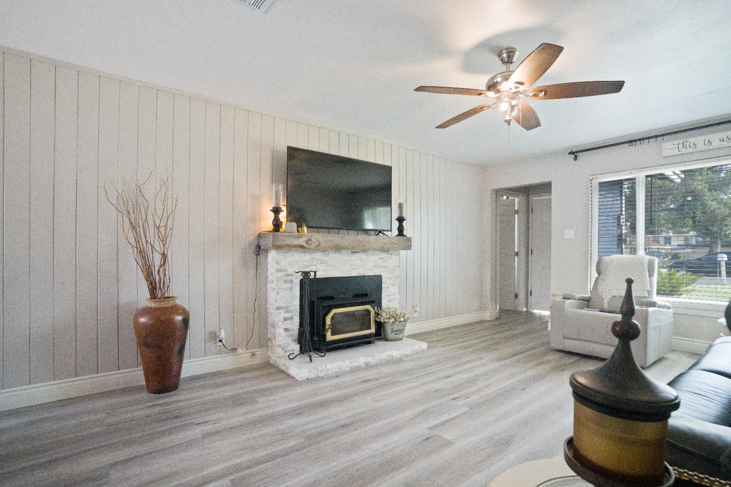 1403 East Griffith Way Fresno, CA 93704 - Photo 25 of 27 a living room with furniture a flat screen tv and a fireplace