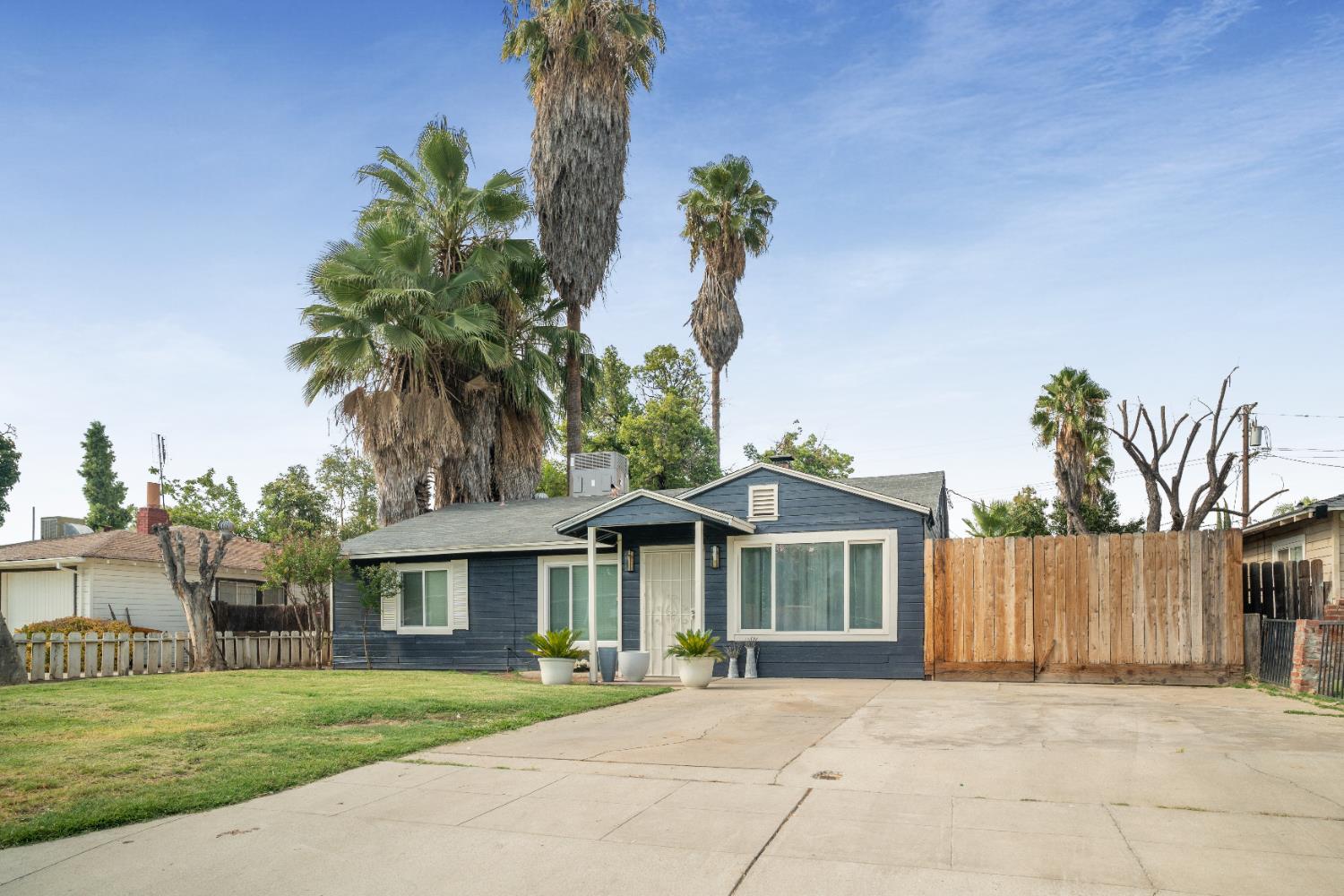 1403 East Griffith Way Fresno, CA 93704 - Photo 27 of 27 a front view of a house with a garden and trees