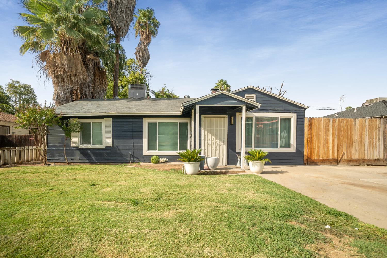 1403 East Griffith Way Fresno, CA 93704 - Photo 3 of 27 a front view of a house with a garden and patio