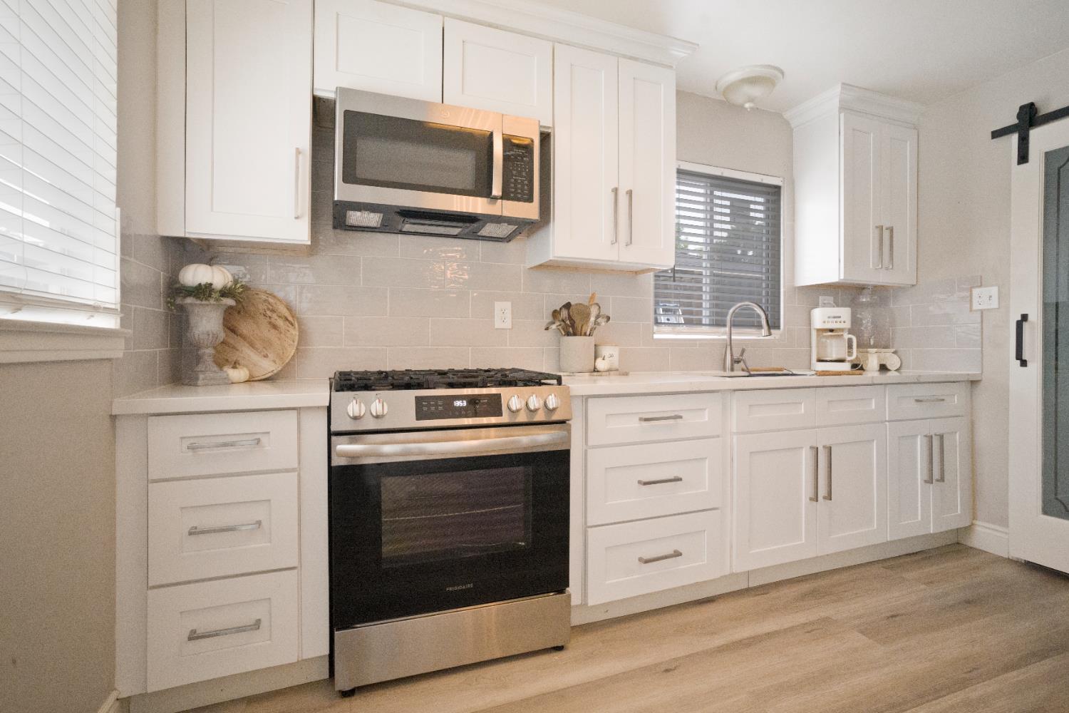 1403 East Griffith Way Fresno, CA 93704 - Photo 4 of 27 a kitchen with white cabinets stainless steel appliances and sink