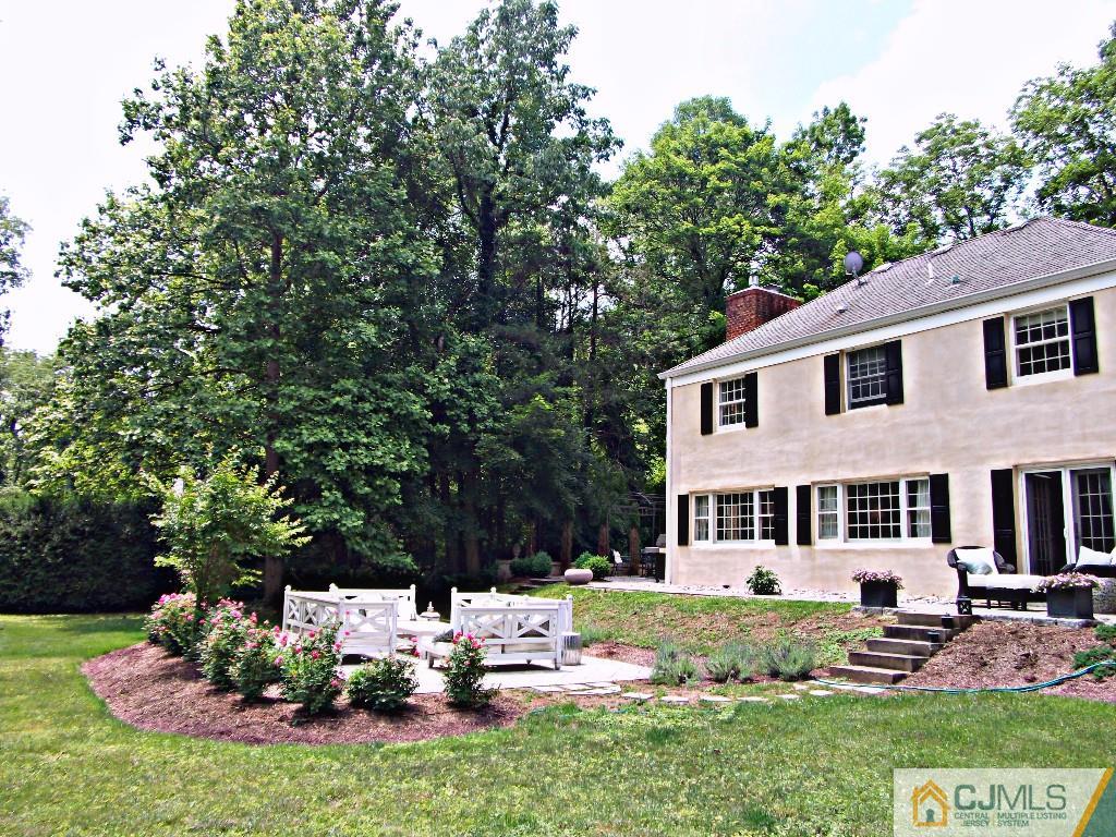 101 Red Hill Road Princeton, NJ 08540 - Photo 3 of 22 a backyard of a house with table and chairs potted plants and large tree