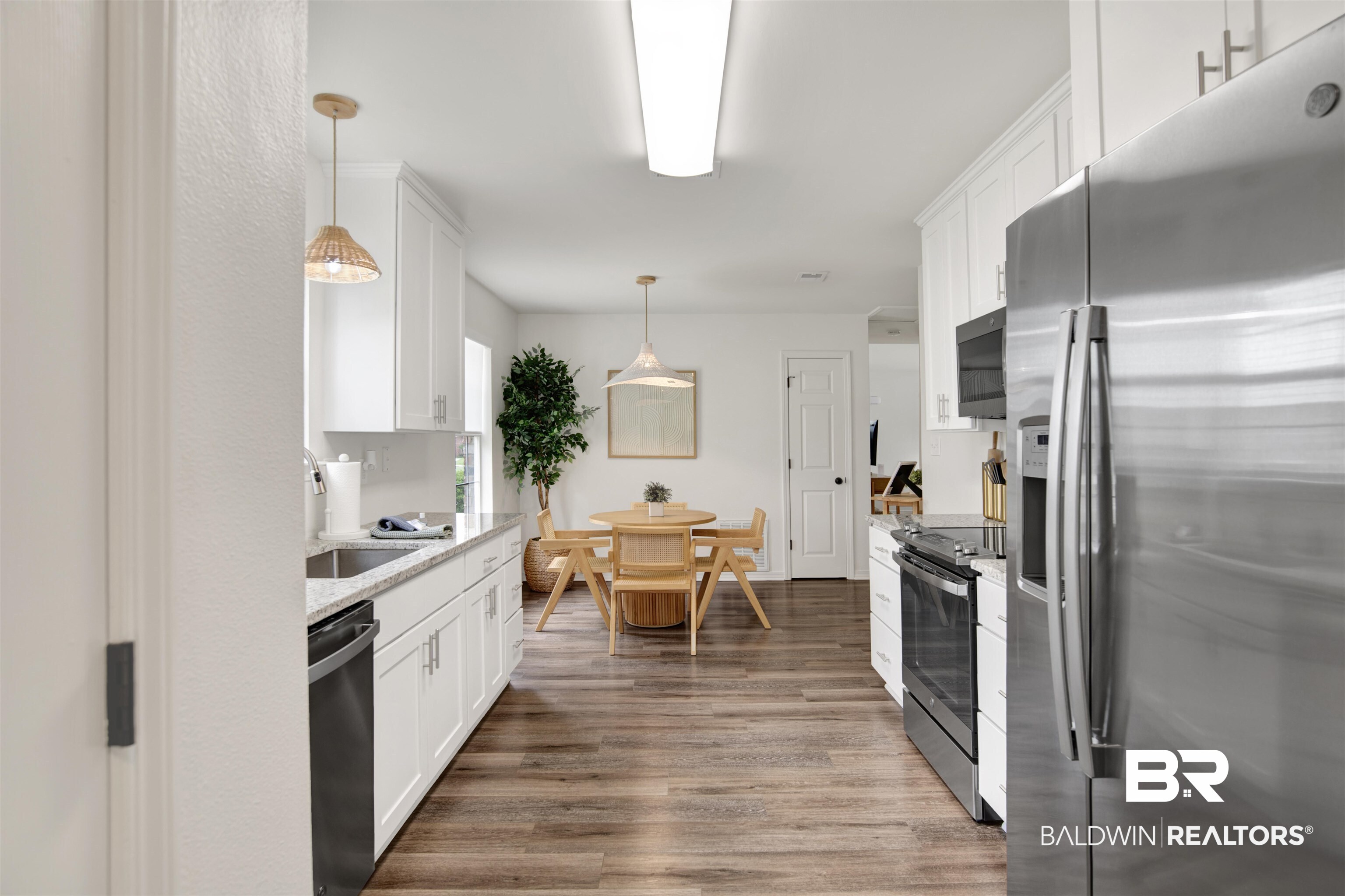 4012 Kendallbrook Loop Foley, AL 36535 - Photo 8 of 31 Kitchen featuring stainless steel appliances, white cabinetry, wood finished floors, and pendant lighting