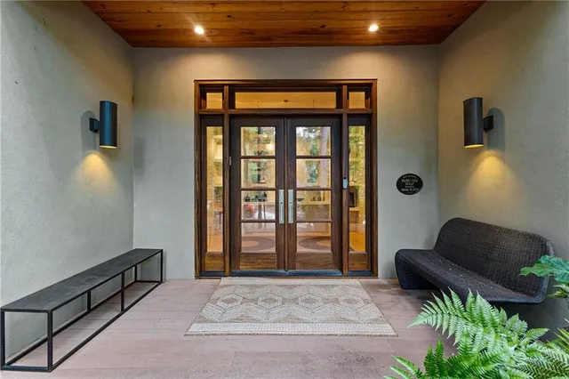 a living room with stainless steel appliances furniture a rug and a kitchen view