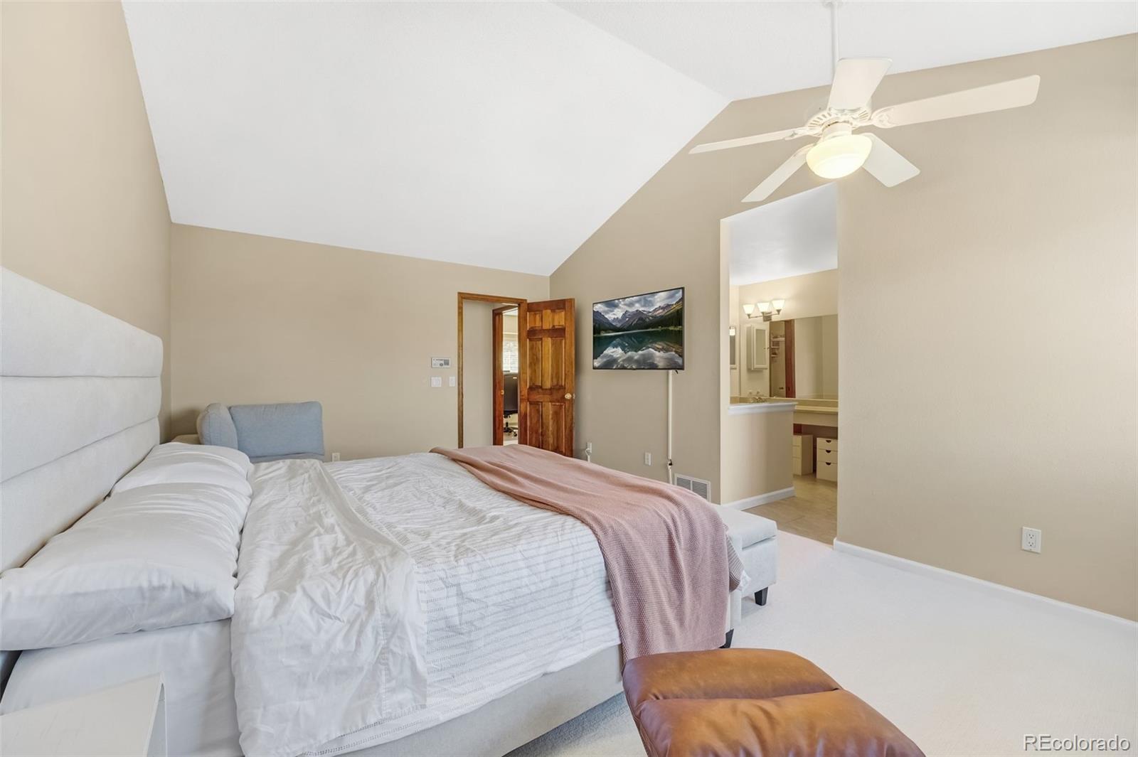 1470 South Quebec Way, Unit 282 Denver, CO 80231 - Photo 12 of 38 a bedroom with a bed and a chandelier