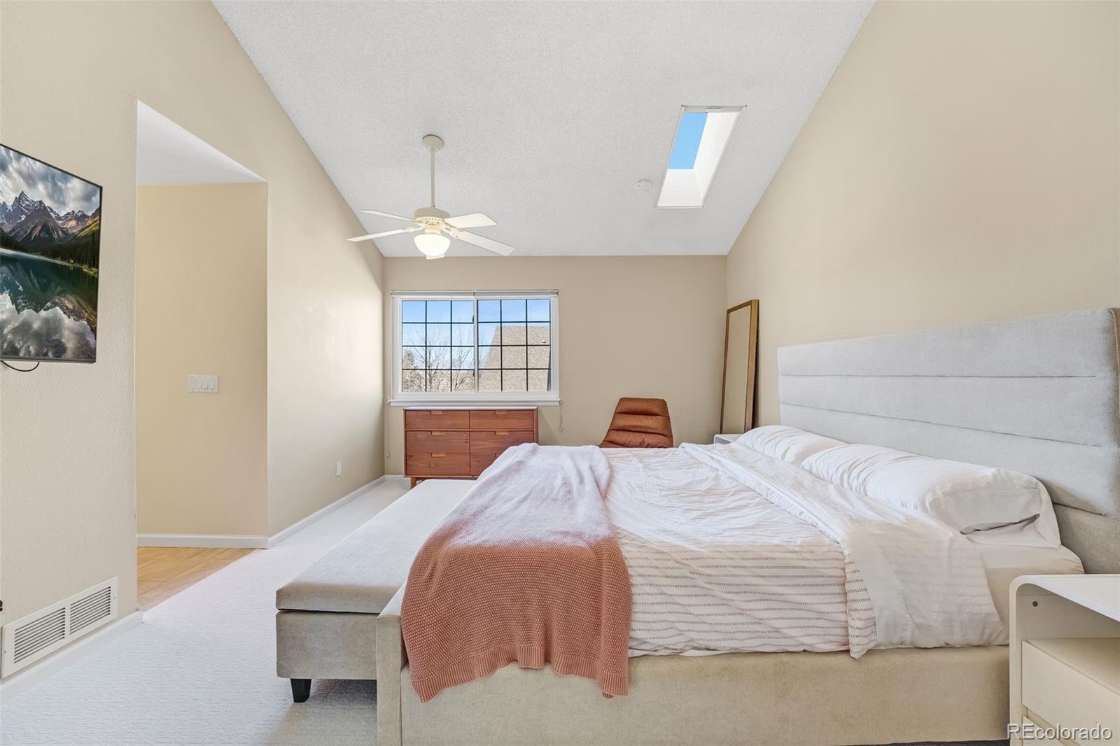 1470 South Quebec Way, Unit 282 Denver, CO 80231 - Photo 13 of 38 a bedroom with a bed and a flat screen tv