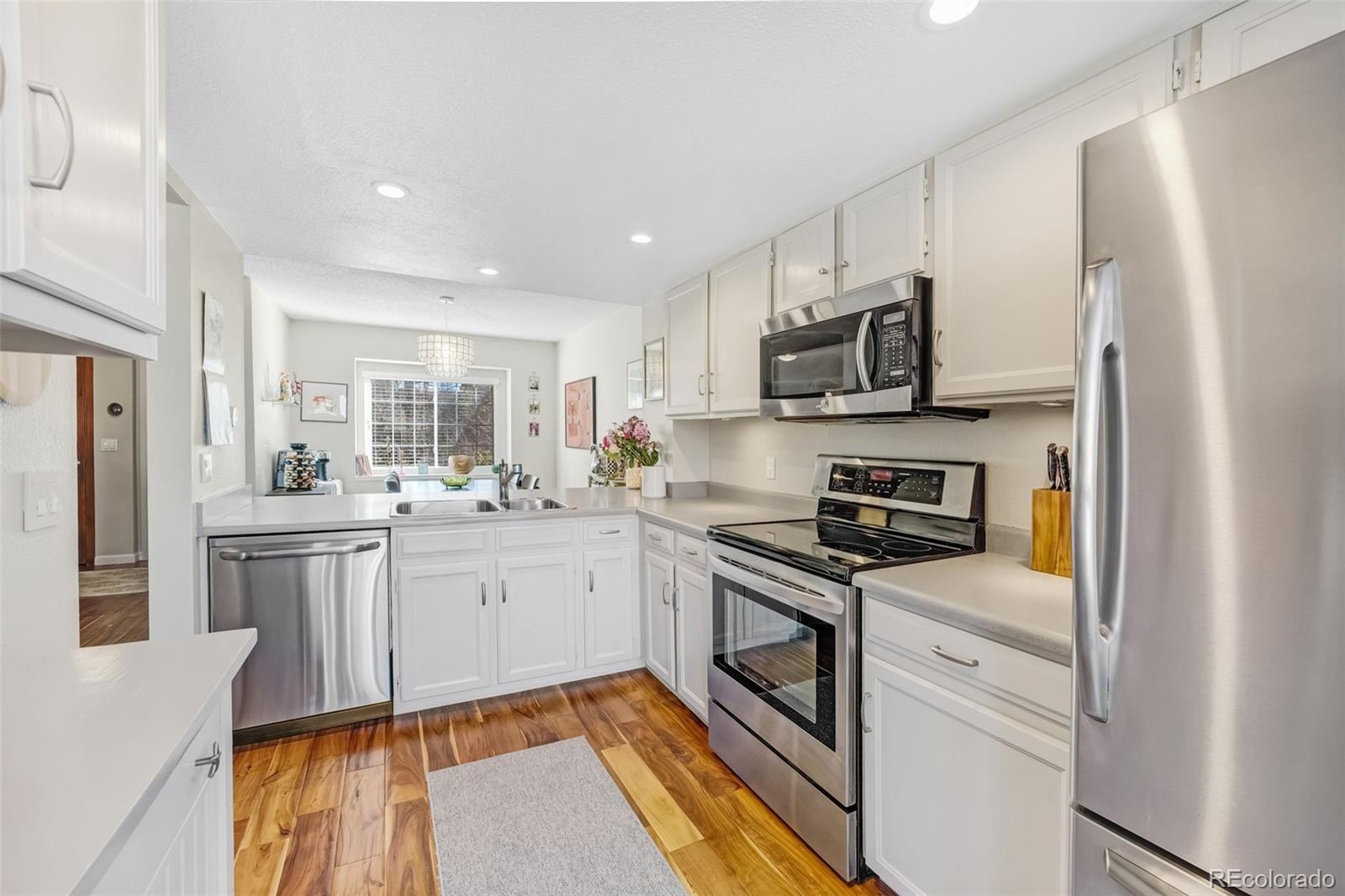 1470 South Quebec Way, Unit 282 Denver, CO 80231 - Photo 6 of 38 a kitchen with stainless steel appliances granite countertop a refrigerator stove microwave and sink