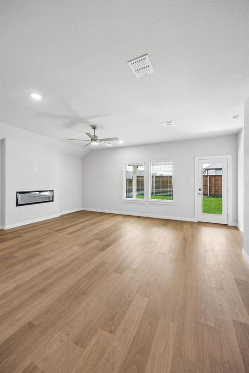 1448 Companero Street Haslet, TX 76052 - Photo 13 of 35 an empty room with wooden floor and windows