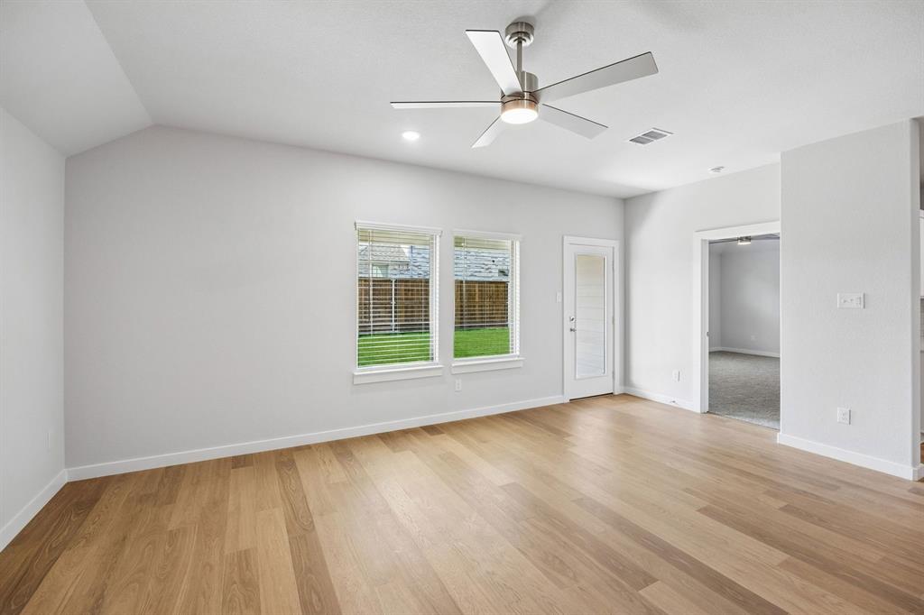 1448 Companero Street Haslet, TX 76052 - Photo 14 of 35 an empty room with wooden floor fan and windows