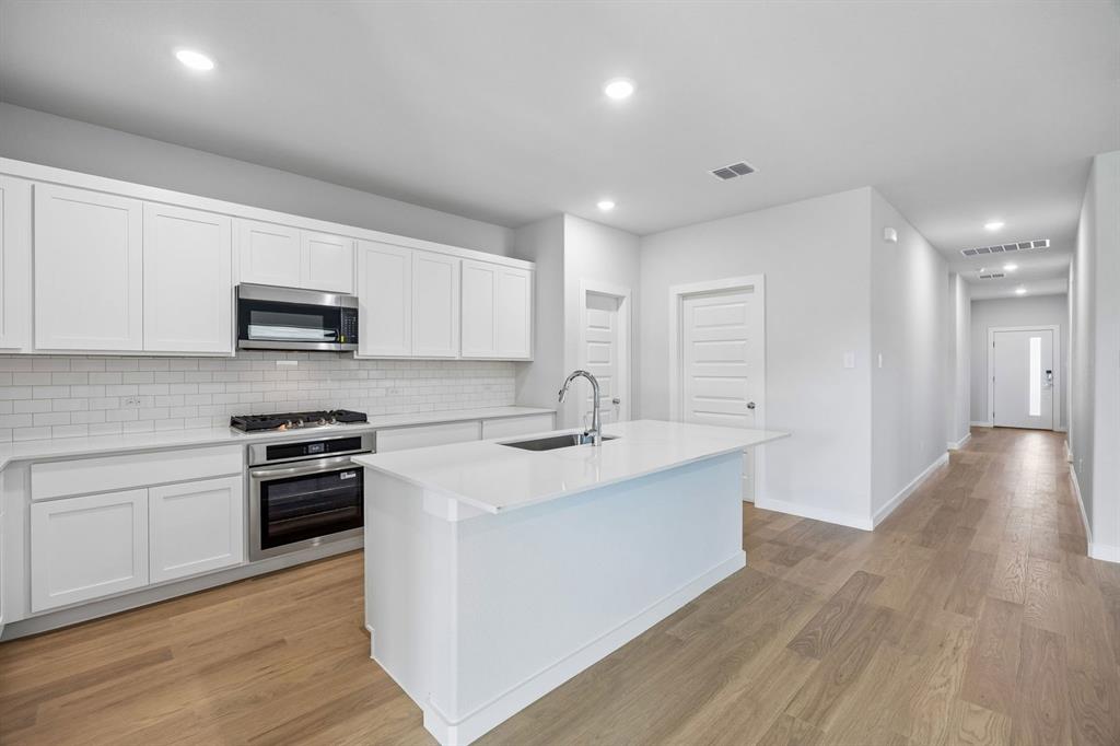 1448 Companero Street Haslet, TX 76052 - Photo 7 of 35 a kitchen with stainless steel appliances granite countertop a sink and microwave