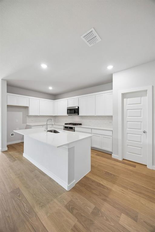 1448 Companero Street Haslet, TX 76052 - Photo 9 of 35 a large white kitchen with kitchen island a sink a stove and a refrigerator