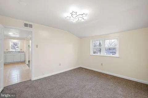 a view of a big room with windows and chandelier fan