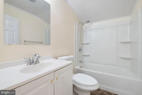 a bathroom with a sink toilet vanity tub and shower