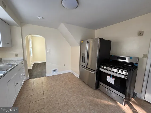 a kitchen with granite countertop a refrigerator and a stove top oven