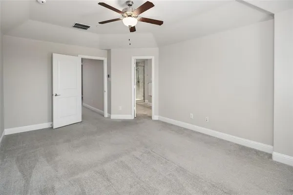 an empty room with chandelier fan