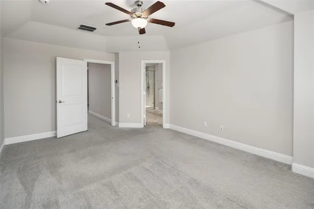 an empty room with chandelier fan