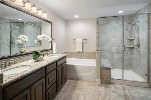 a bathroom with a granite countertop sink mirror and a bath tub