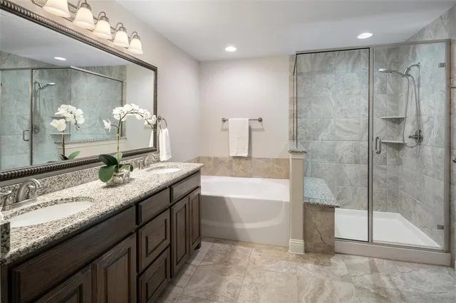 a bathroom with a granite countertop sink mirror and a bath tub